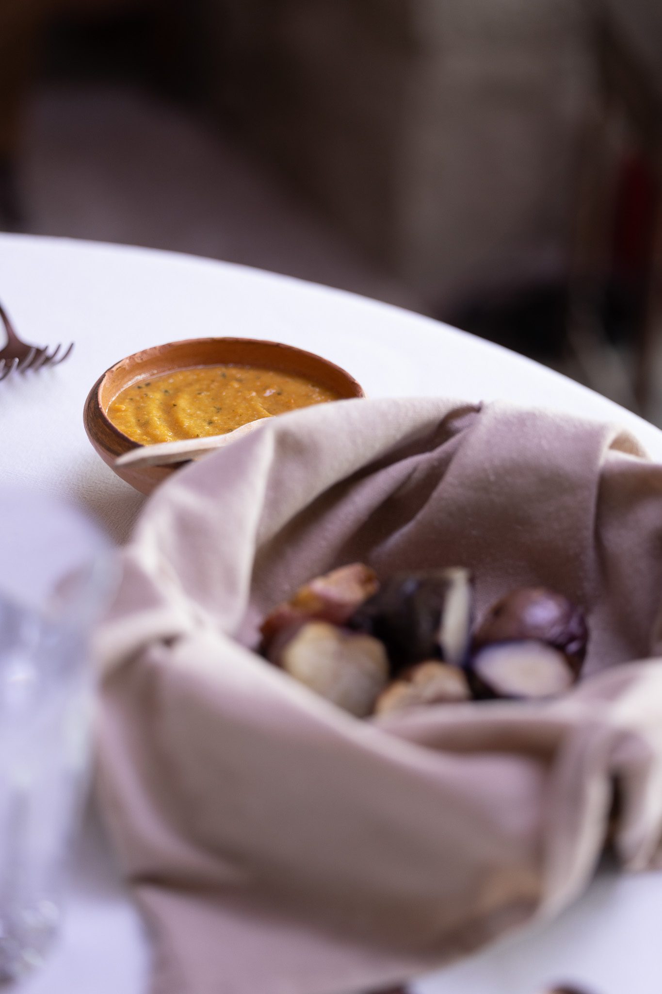 Artisanal bread and sauce served on a fine dining table in an Andean lodge.