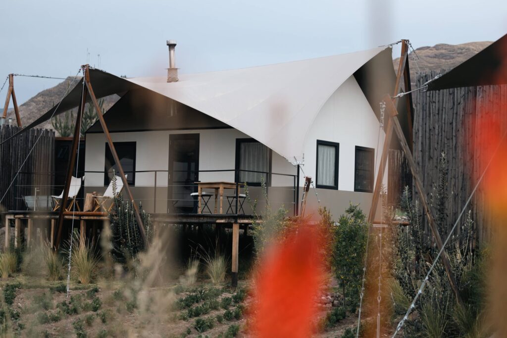 Luxury glamping lodge with canvas roof and private deck set in an Andean landscape.